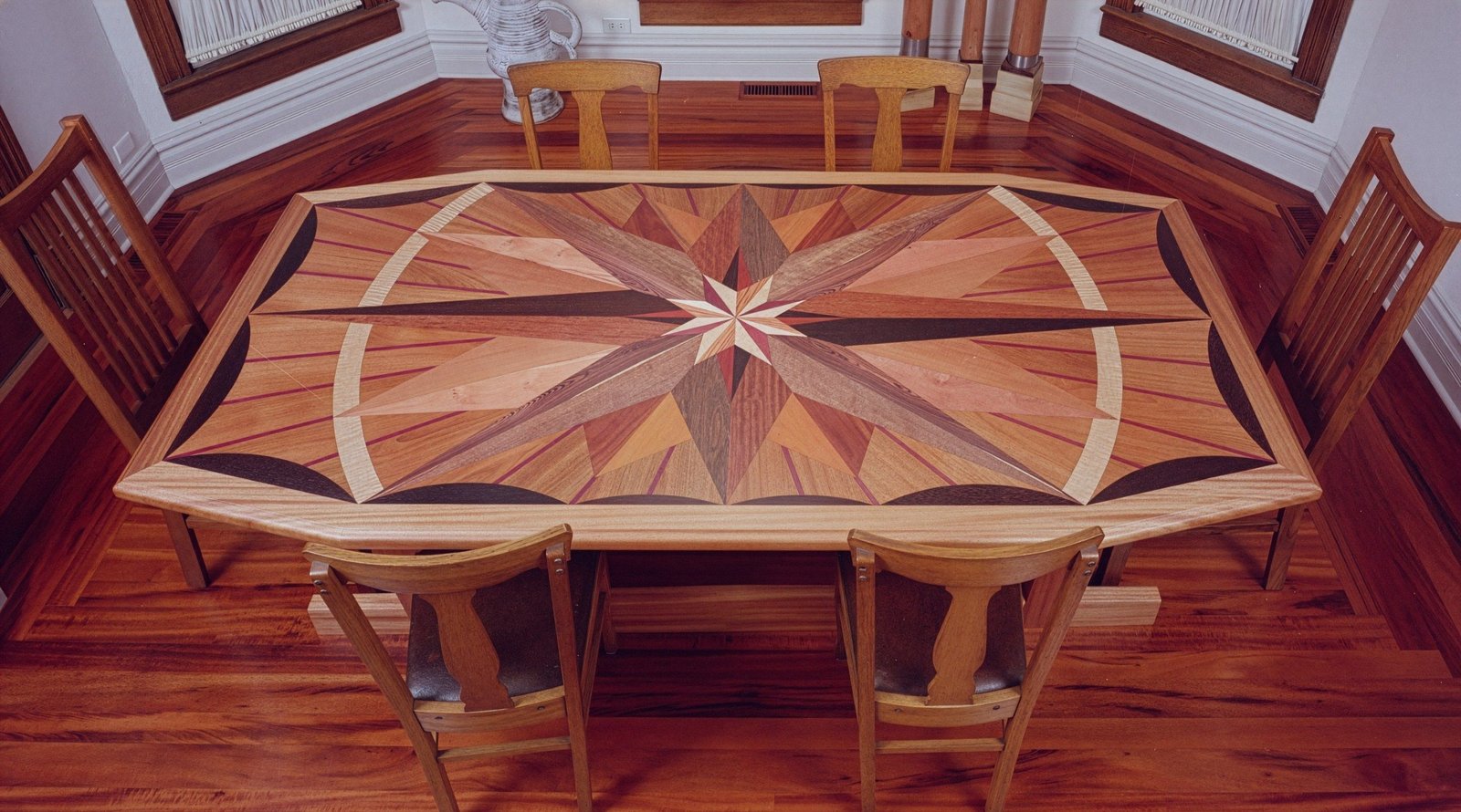 Dining table with a marquetry compass star inlaid across the whole top — custom commission
