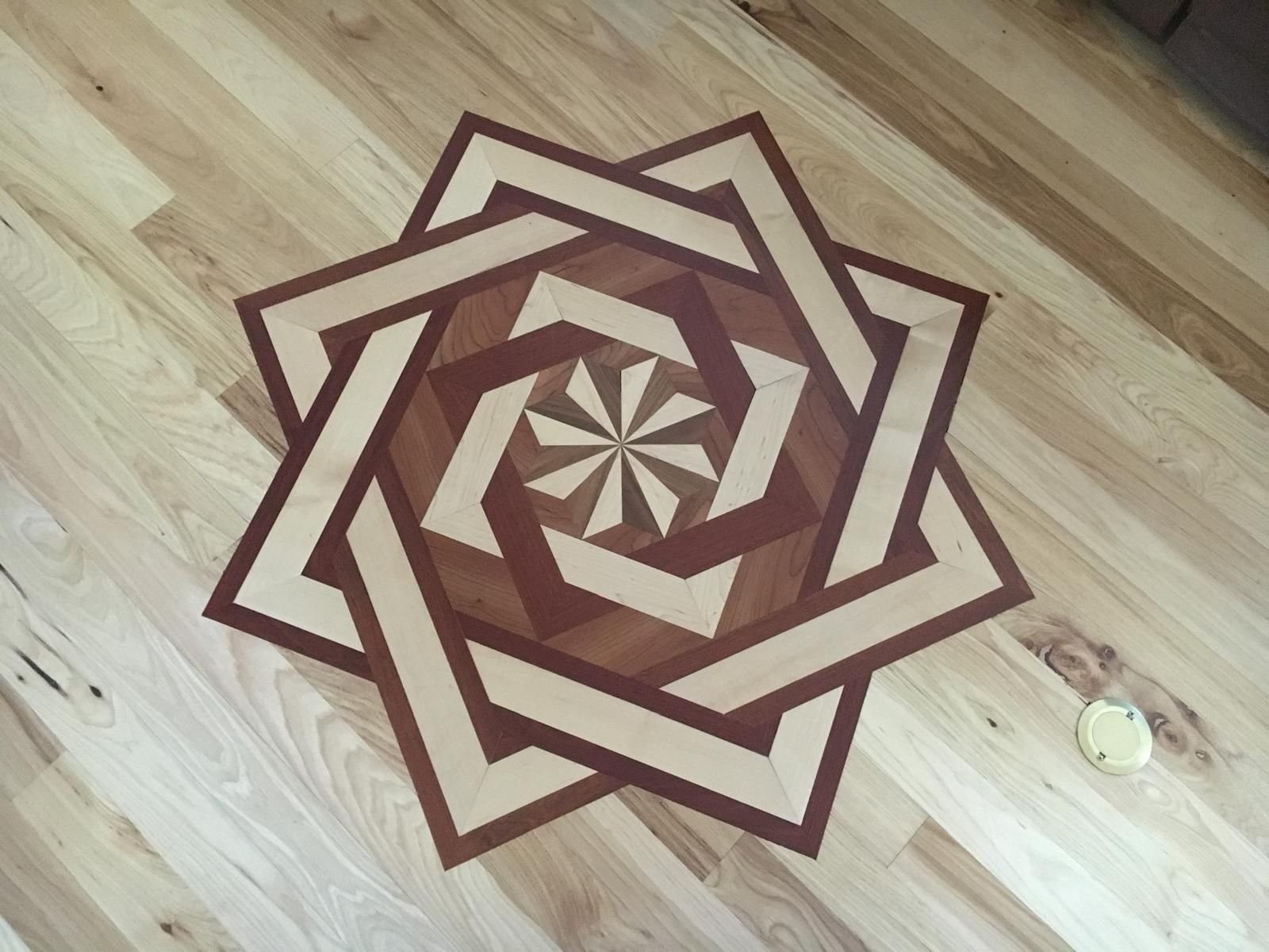 Interlaced star medallion of two overlaid squares set into a light plank field — padauk, maple and hickory, custom commission