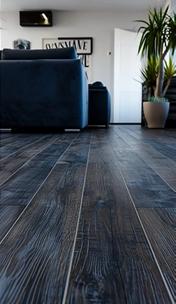 Dark hardwood flooring with deep grain beside a potted plant