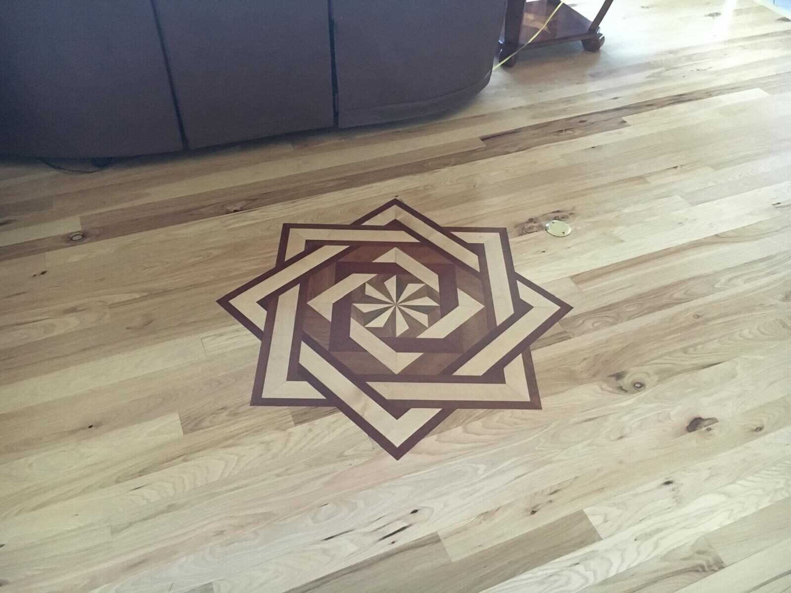 Star-pattern hardwood mosaic medallion inlaid into a wood floor