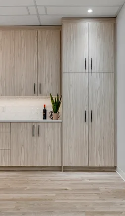 White kitchen cabinetry above pale wood-look plank flooring
